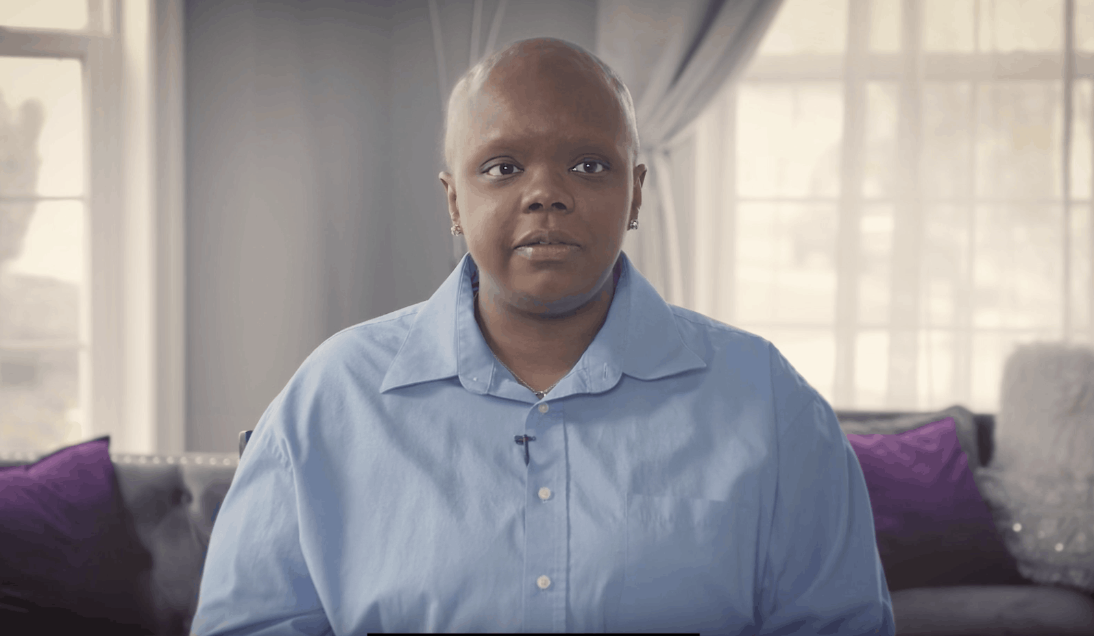 LaToya sits indoors in a pale blue shirt, looking at the camera.