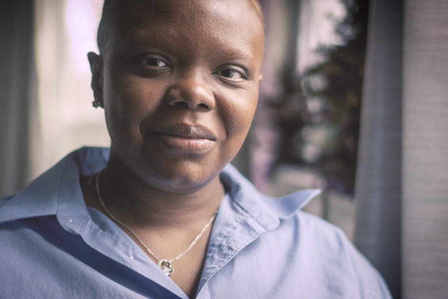 LaToya looks at the camera in a pale blue collared shirt.
