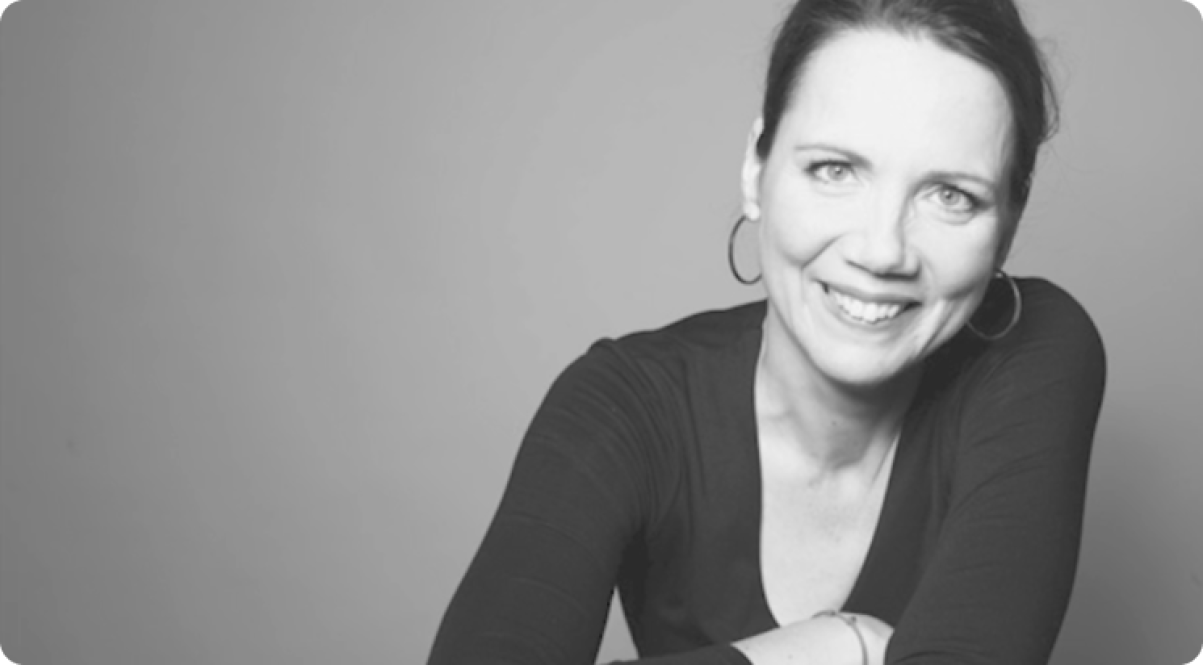 A black-and-white portrait of Katja smiling.